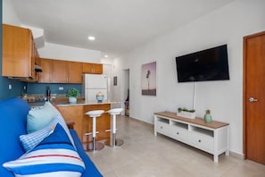  A flat-screen TV is mounted on a wall opposite the sofa, creating a harmonious and functional space.