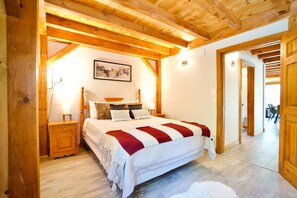 The downstairs bedroom offers a queen bed flanked by bedside tables with lamps.