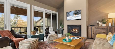 Smart TV, cozy gas fireplace, and patio access with views