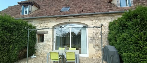 Terrasse privée (salon de jardin et barbecue), vue sur le jardin et la piscine