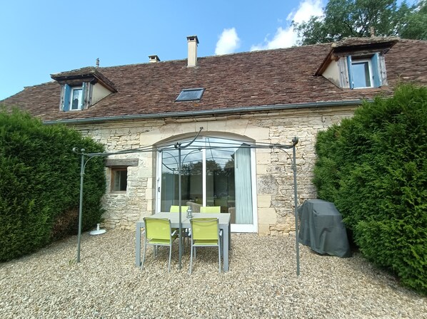 Terrasse privée (salon de jardin et barbecue), vue sur le jardin et la piscine