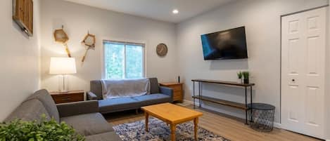 Check out this living room! High ceilings, tons of light and plenty of accents to make you feel at home.  Both couches fold down into 1 person sleepers
