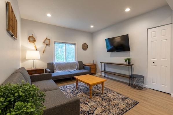 Check out this living room! High ceilings, tons of light and plenty of accents to make you feel at home.  Both couches fold down into 1 person sleepers