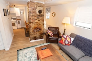 The living room looking into the dining area with exposed brick that adds coziness