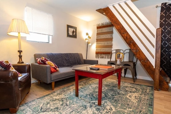 A shot of the living room, with a comfy sleeper sofa (for 1) an armchair and additional 4 seats
