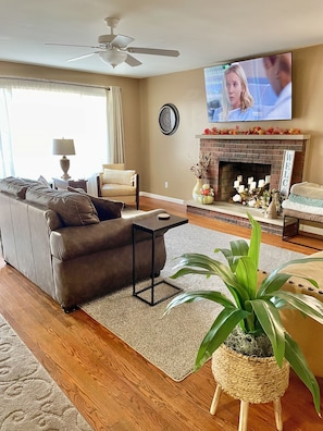 Spacious living room with 2 loveseats, 2 chairs and 65” Roku TV