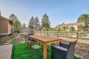 Fenced-in backyard with forest views and outdoor dining—perfect for cookouts and family gatherings.

