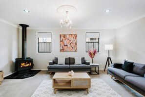 The lounge area offers a comfy sofa and armchairs where guests can settle in with a movie, while an indoor fireplace keeps everyone cosy over the cooler months. 