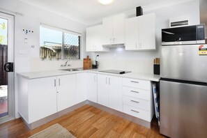 Fully equipped kitchen with stove, fridge/freezer, microwave and other staples