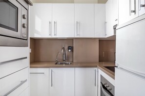 Sleek and modern kitchen, fully equipped with stainless steel appliances for a seamless cooking experience.