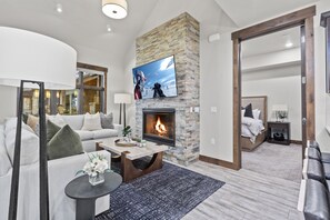 Contemporary furniture including a sectional sofa with sofa sleeper, a Smart TV, and a cozy gas fireplace. Step out onto the adjacent deck and you will also find outdoor furnishings and a BBQ grill.