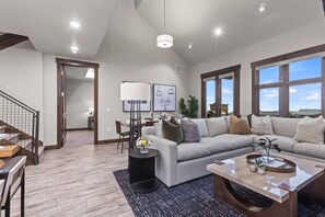 Contemporary furniture including a sectional sofa with sofa sleeper, a Smart TV, and a cozy gas fireplace. Step out onto the adjacent deck and you will also find outdoor furnishings and a BBQ grill.