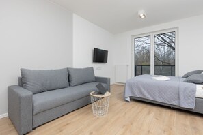 Another angle of the living room, emphasizing the bright and airy feel due to the large windows and minimalist décor.