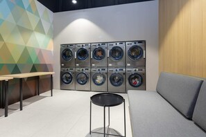 A communal laundry area with modern washers and dryers, designed for residents’ convenience.