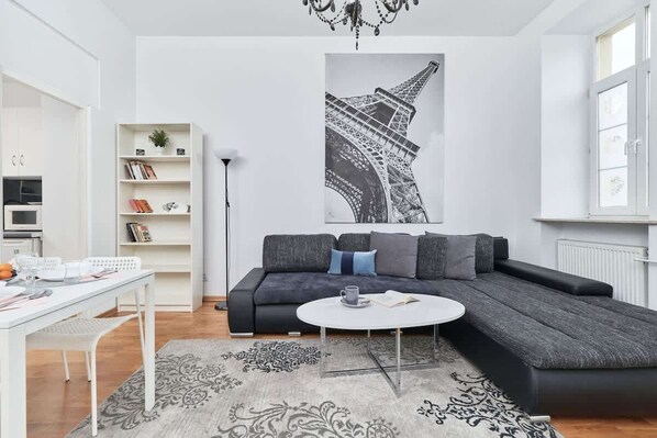 A cozy and elegant living area with a comfortable sofa, a modern coffee table, and stylish decor on the wall.