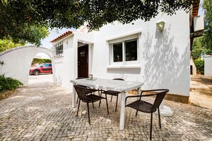 outside patio area under the shady Alfaroba tree. 