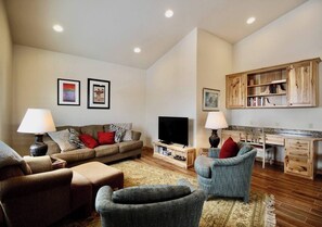 Relax on the plush pullout couches, offering a comfortable seating option during the day and a cozy sleeping space at night. A sleek TV stands ready to entertain.