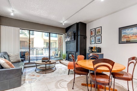 Vacation Rentals in Park City at Edelweiss Haus A102: Living room with dining area, patio access, gas fireplace, large TV