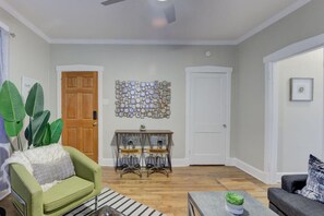 The living room from the window view shows the main door and the room from a different angle.