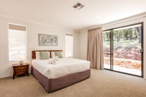 The luxurious primary bedroom features a king bed, large windows with serene views, and an ensuite with a soaking bath.