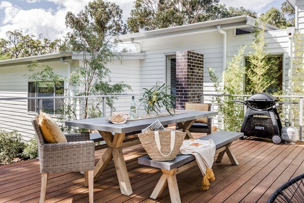 The deck houses a BBQ and outdoor table set for alfresco dining.