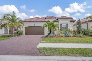 There is a Lush Subtropical Landscape Surrounding the Home Along With Perfectly Manicured Lawns