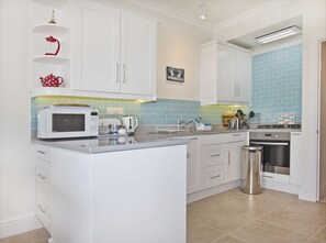 The kitchen is well equipped with a dishwasher, washing machine and dryer