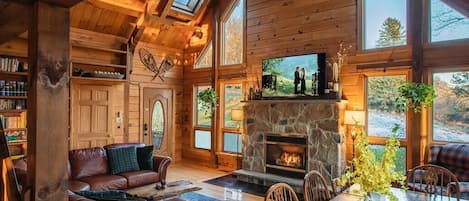 Cozy up by the crackling fire in our inviting cabin living room, where warmth and comfort await.