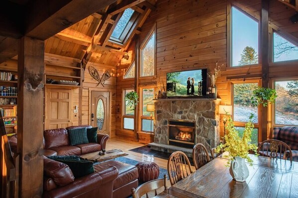 Cozy up by the crackling fire in our inviting cabin living room, where warmth and comfort await.