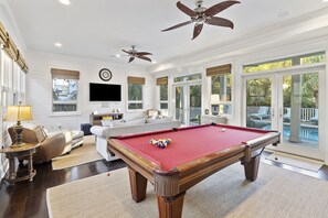 Media room with a second living area, pool table, wet bar, and access to the pool.