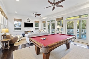 Media room with a second living area, pool table, wet bar, and access to the pool.