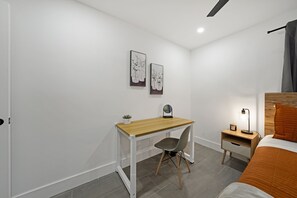 Office desk and chair, a soft lamp graces the room, casting a warm glow for late-night reading. 