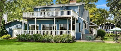 Back of home with two decks that look out to the water.