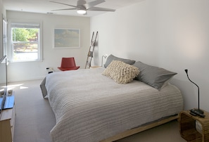 Main bedroom (18'x11') with a super cozy king bed, corner window seating & TV