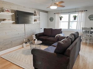 Bright and cozy living room with shiplap wall and plenty of seating.