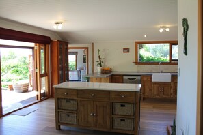 Large open-plan kitchen with oak cabinetry, butler sink and new dishwasher.