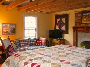 Bedroom with queen bed, queen futon, hand hewn timbers and fireplace 