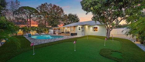 This is the backyard of your dreams with a private heated pool, and actual putt putt field, lounge furniture, and more!