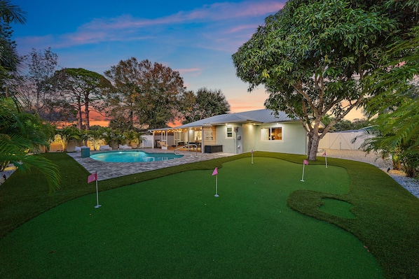 This is the backyard of your dreams with a private heated pool, and actual putt putt field, lounge furniture, and more!