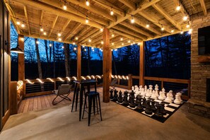 Lighted entertainment porch with TV, fireplace, giant chess, zero gravity loungers
