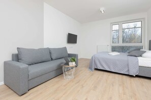 Another angle of the living room, emphasizing the bright and airy feel due to the large windows and minimalist décor.