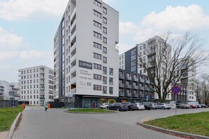 The apartment building with a well-maintained entrance surrounded by landscaped greenery.