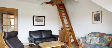 Wohnzimmer mit Treppe in den ausgebauten Dachboden 