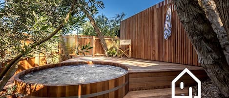 Experience the therapeutic benefits and divine scent of a cedar hot tub
