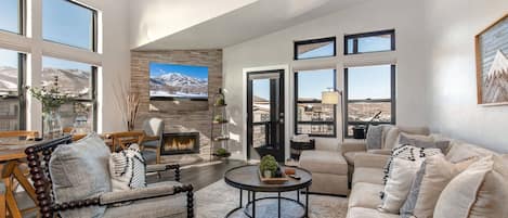 Cozy space with a fireplace, natural light, and outdoor views.