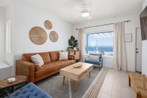 Chill out in the family room's expansive comfort, featuring a plush couch, laid-back lounge chairs, a top-notch TV, a stash of toys and games in a cool cabinet, all against the backdrop of breathtaking sea views!