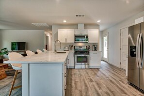 Fully Stocked Kitchen with Modern Amenities: Cook meals with ease in this updated kitchen featuring stainless steel appliances, ample counter space, and a breakfast bar—ideal for extended stays or hosting.