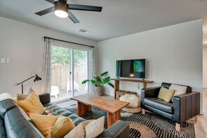Cozy and Bright Living Space with Smart TV: This inviting living room offers comfortable seating, natural light, and a smart TV for streaming your favorite shows after a day of exploring.