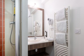 The bathroom combines functionality and style, featuring sleek fixtures and essential amenities.