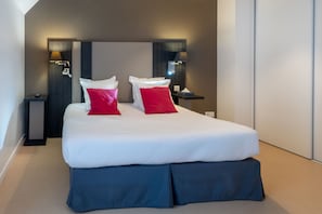 The tranquil bedroom boasts a double bed with pillows and elegant bedside lighting, offering a serene retreat for restful nights after exploring the city.
